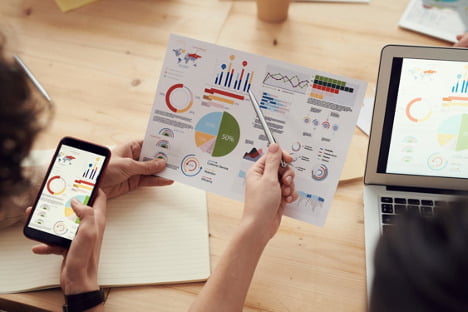 Two individuals assessing marketing analytics of integrated marketed channels